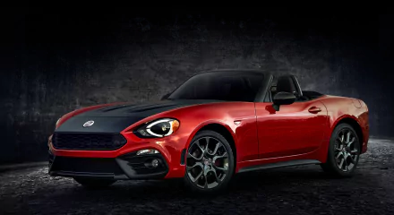 HD PC desktop wallpaper featuring a red Fiat 124 Spider sports car against a dark textured background.