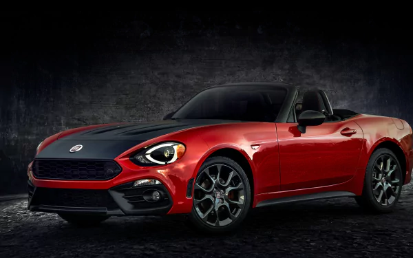 HD PC desktop wallpaper featuring a red Fiat 124 Spider sports car against a dark textured background.