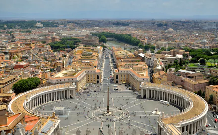 Panoramic cityscape of Rome featuring St. Peter's Square and the Vatican, under a clear sky, captured as an HD desktop wallpaper and background.