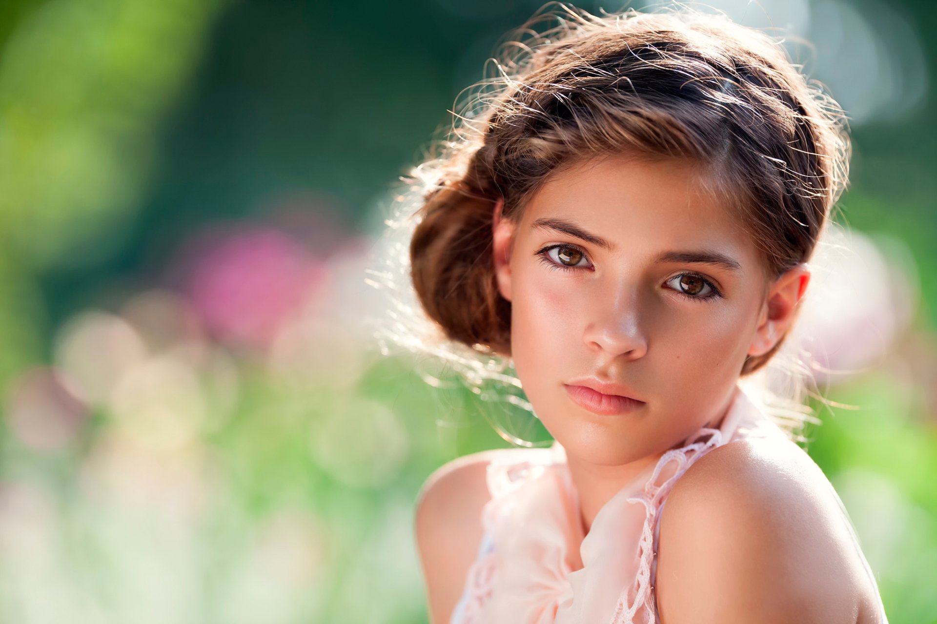 A woman gazes thoughtfully, framed by a soft bokeh background of colorful blooms, creating a serene and captivating HD wallpaper for desktop use.