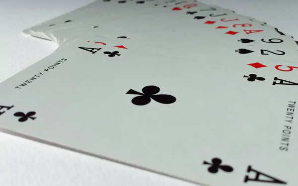 HD desktop wallpaper featuring a close-up of a man-made playing card spread, highlighting clubs, diamonds, and hearts suits on a clean white background.