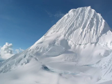 A stunning HD wallpaper showcasing a majestic mountain covered in snow, surrounded by clear blue skies, capturing the beauty of nature in its purest form.