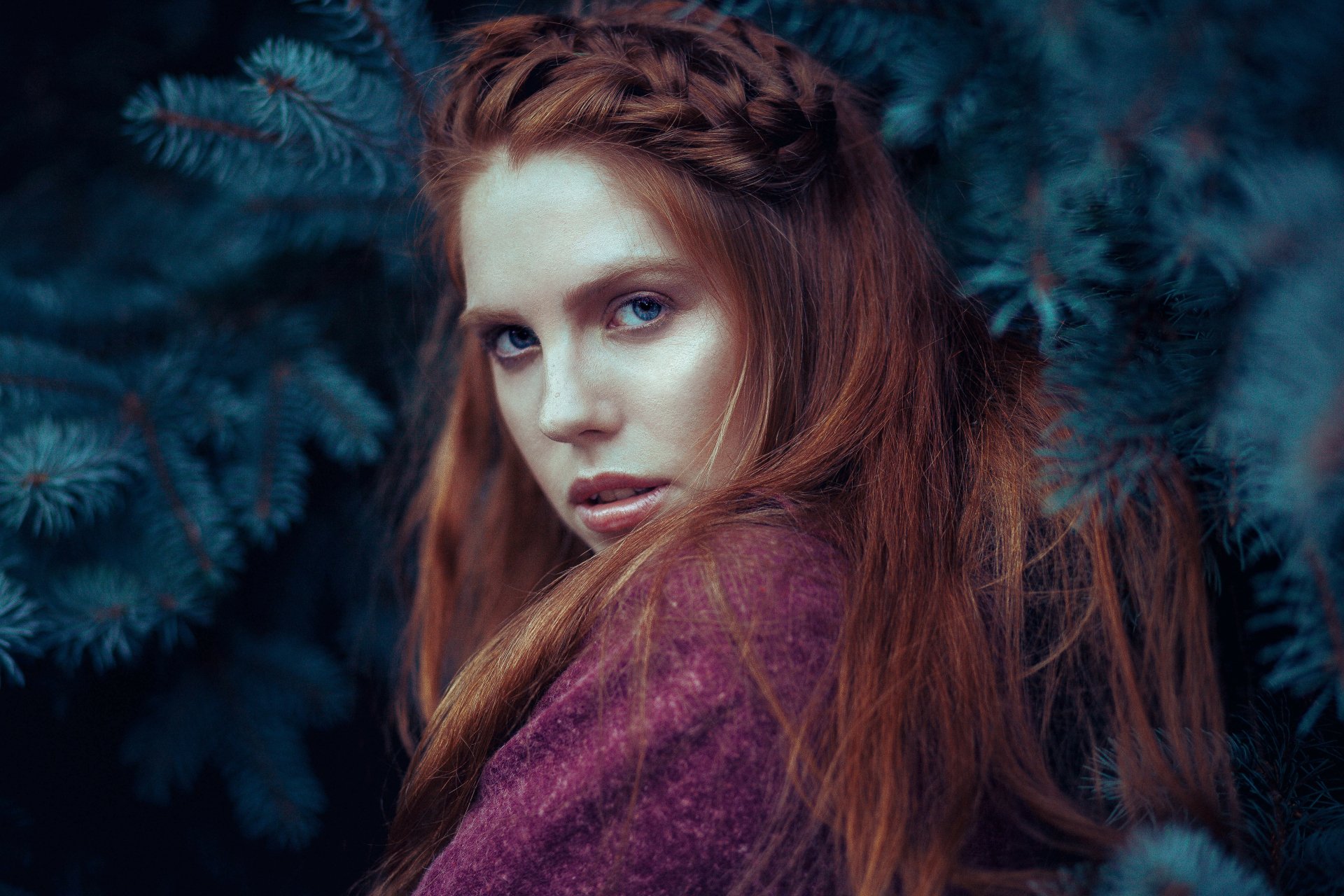 A striking 4K Ultra HD portrait of a redhead woman with blue eyes framed by dark foliage, blending natural beauty with a mysterious, moody atmosphere.