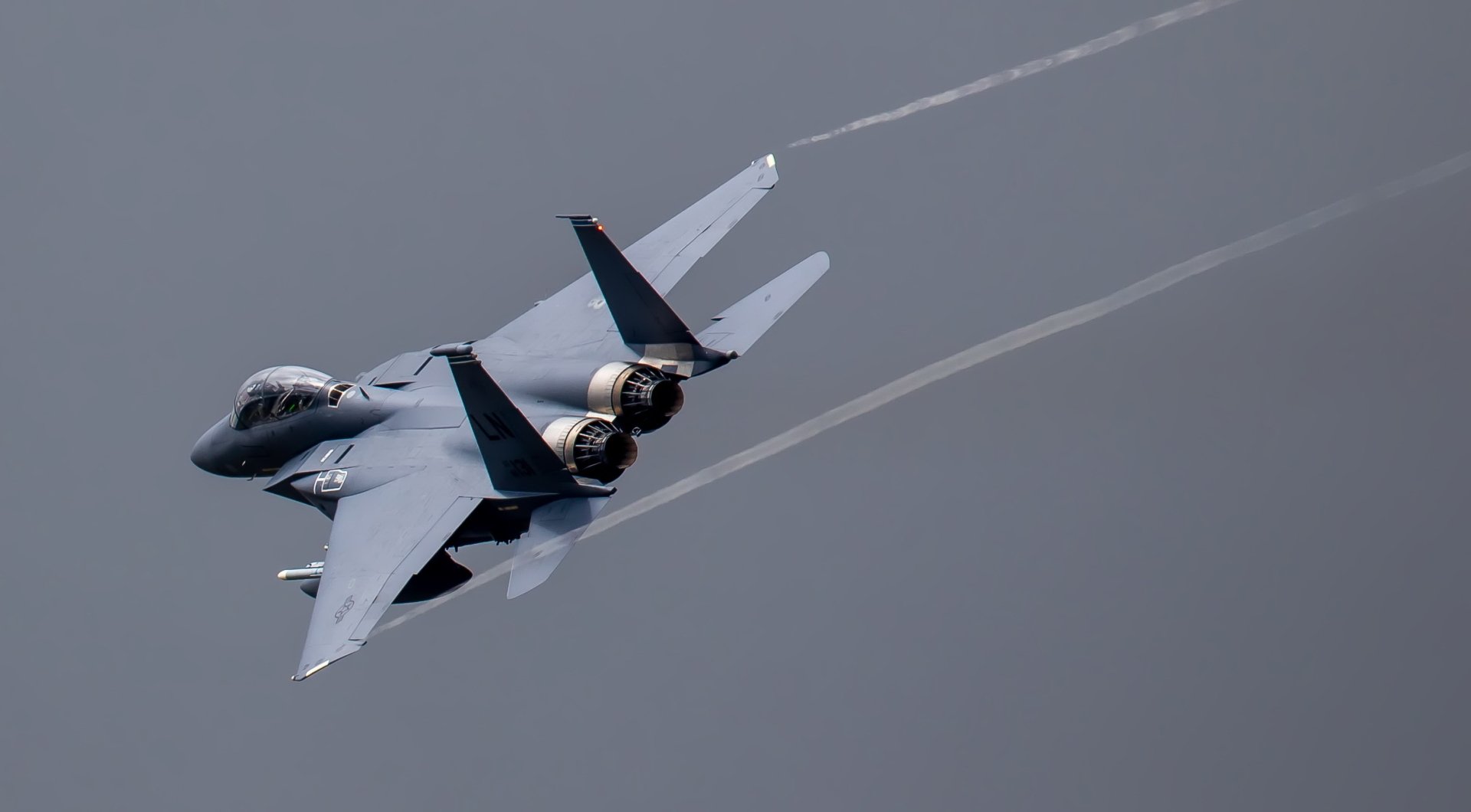 HD desktop wallpaper of a McDonnell Douglas F-15 Eagle jet fighter warplane soaring through the sky, showcasing its military aircraft design and powerful engines.