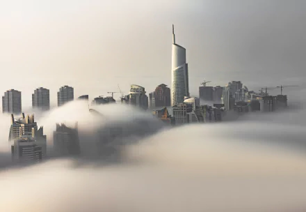 Fog envelops skyscrapers in Dubai, United Arab Emirates, creating a striking urban skyline scene in this HD desktop wallpaper.