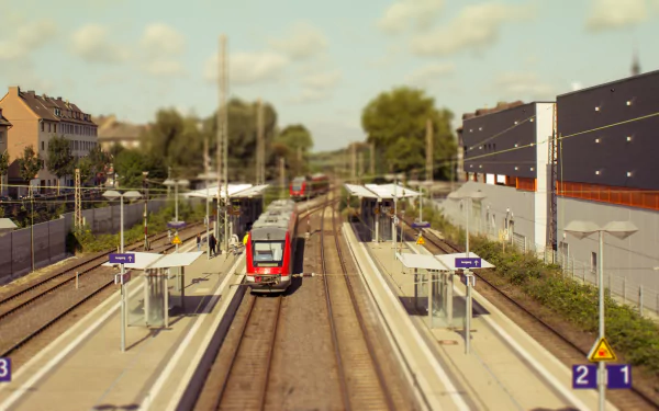 A tilt-shift photograph of a miniature train station, showcasing vibrant trains along the tracks, surrounded by lush greenery, presented in 4K Ultra HD quality.