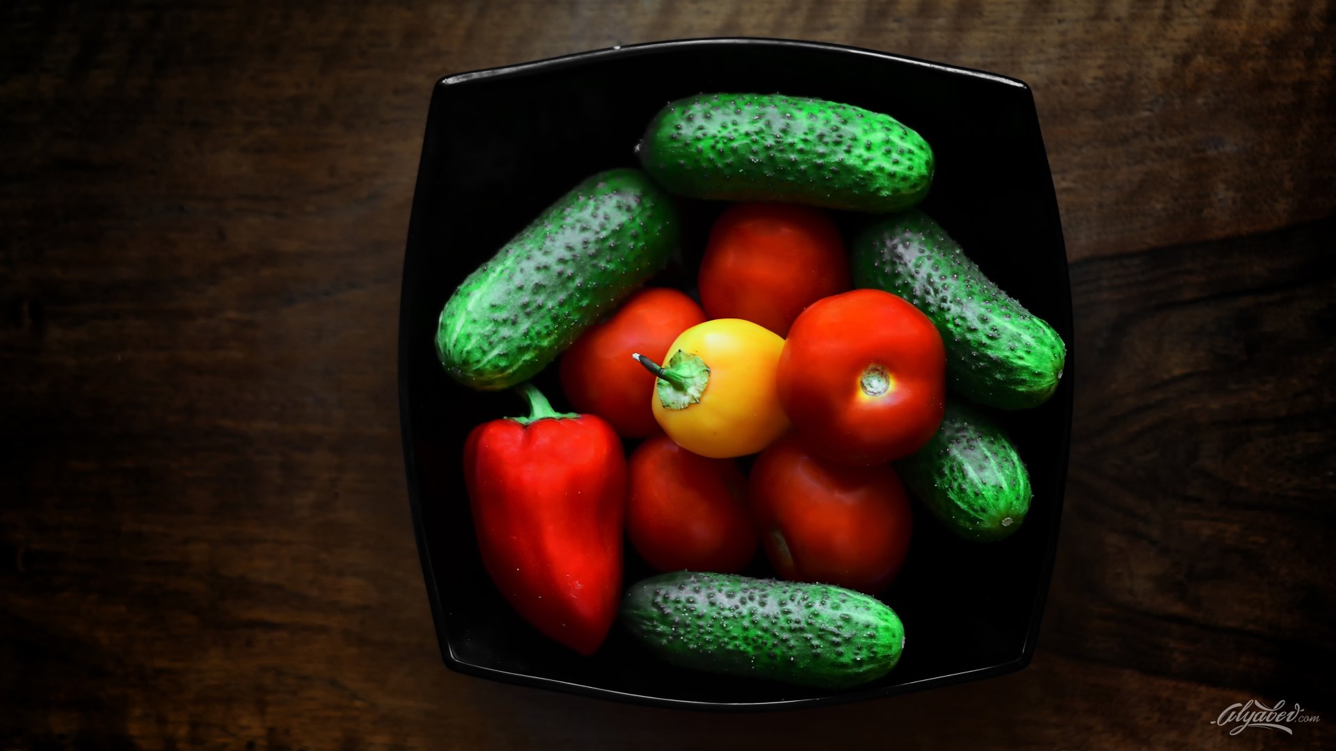 Still life 5K Ultra HD desktop wallpaper: Fruits & Vegetables — red tomatoes and a red pepper arranged with green pickles in a black bowl on dark wood.