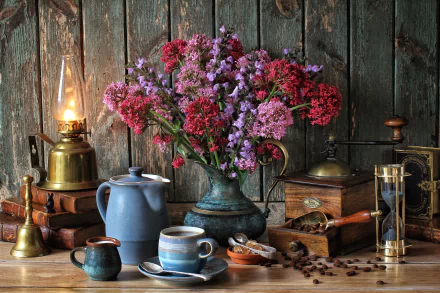 Still life HD desktop wallpaper featuring a vintage lamp, vibrant flowers in a vase, an hourglass, coffee cups, and a manual coffee grinder on a rustic wooden table.