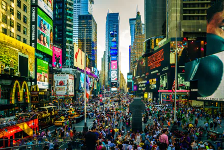 Bustling crowd fills a vibrant Times Square street in New York, USA, surrounded by towering man-made buildings, captured in HD for a dynamic desktop wallpaper.