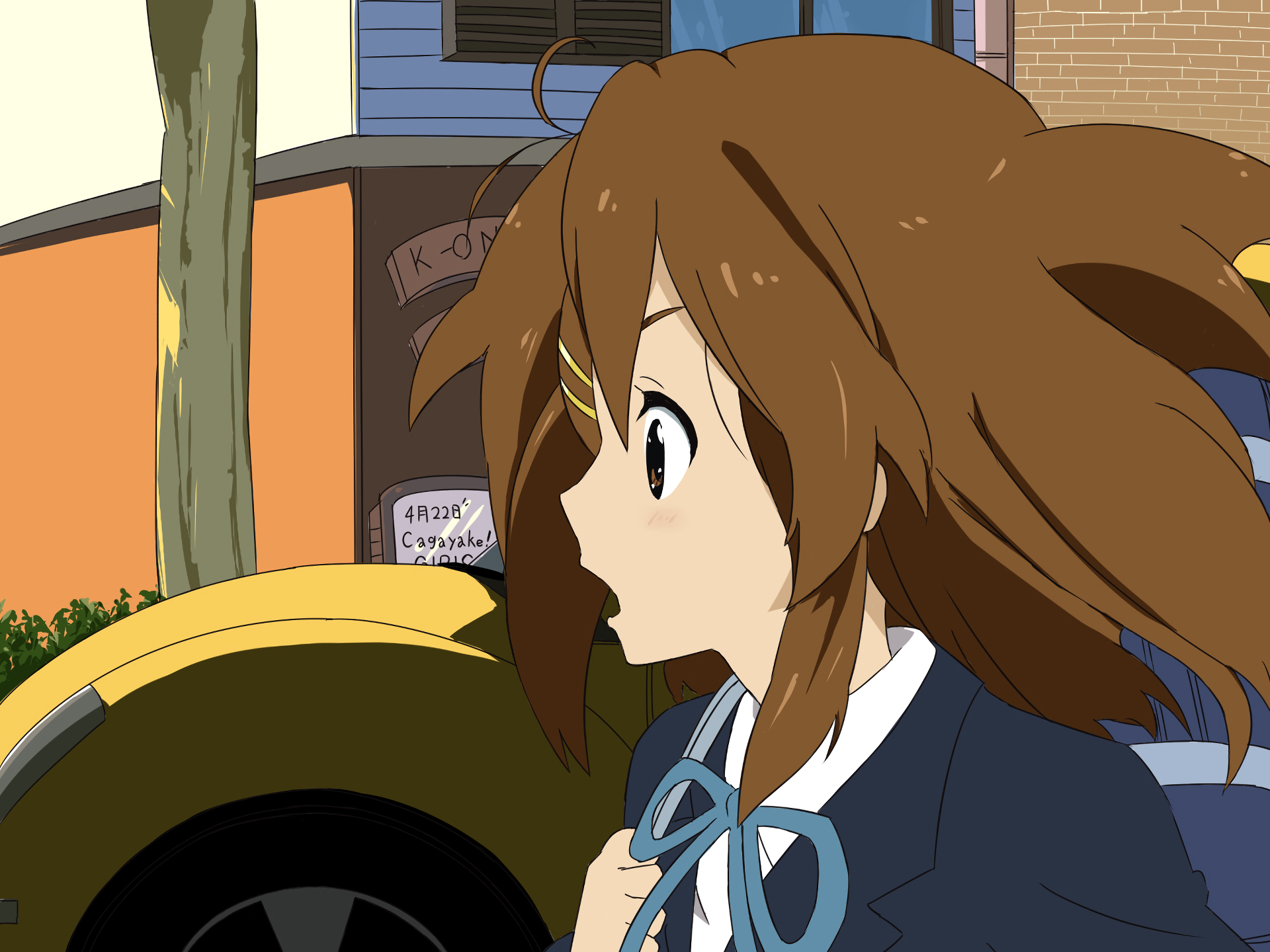 HD PC desktop wallpaper of Yui Hirasawa from K-ON! Anime scene: surprised Yui in school uniform with windblown hair against a colorful street background.