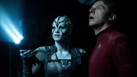 Star Trek Beyond 5K Ultra HD PC wallpaper: an alien woman with white facial markings and a red‑uniform Starfleet officer lit by blue light inside a dark starship interior.