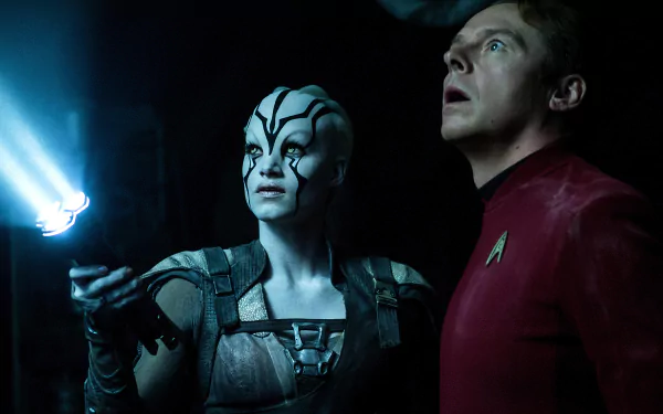 Star Trek Beyond 5K Ultra HD PC wallpaper: an alien woman with white facial markings and a red‑uniform Starfleet officer lit by blue light inside a dark starship interior.