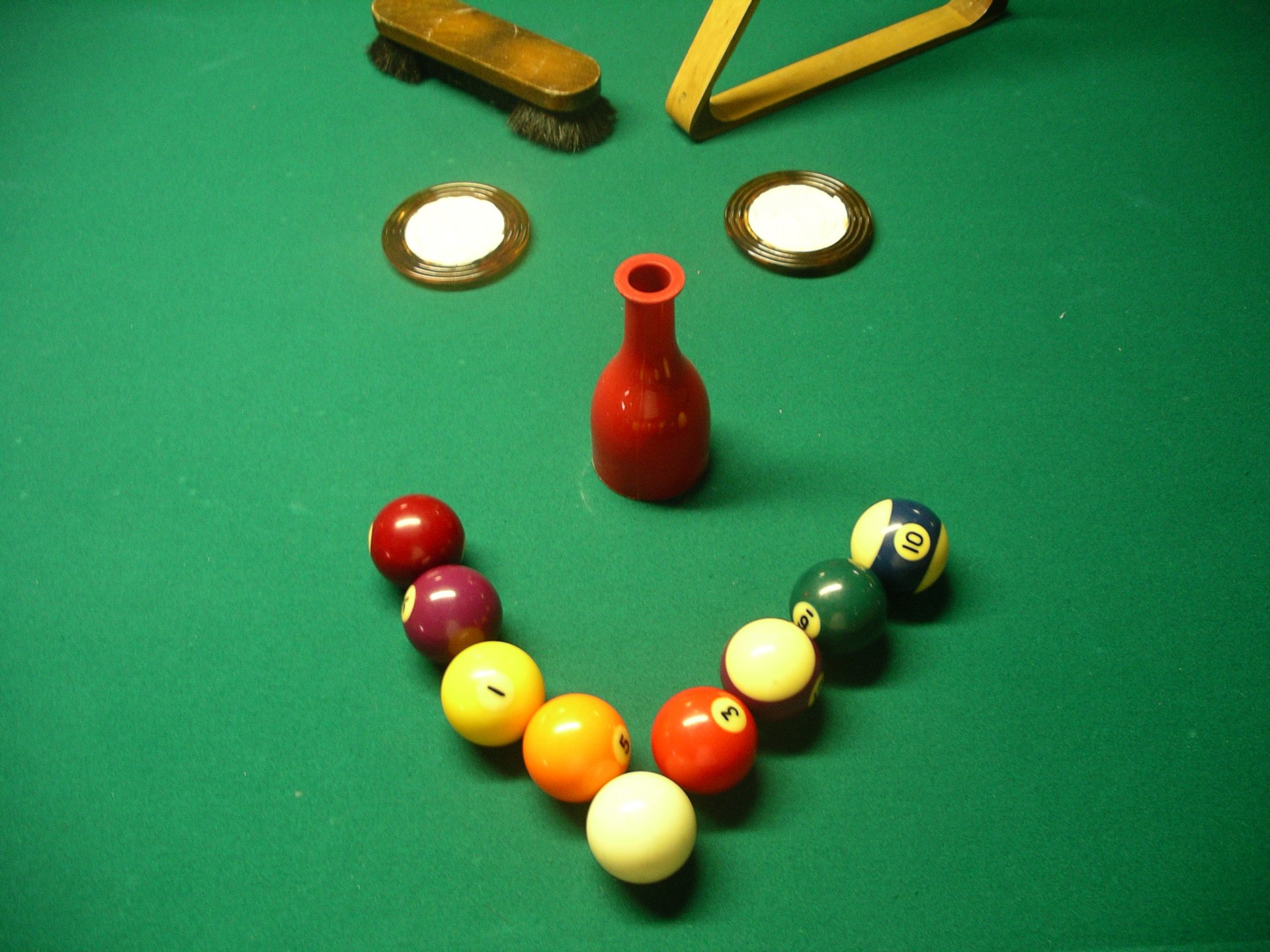 Funny billiard smiley: colorful pool balls and a red bottle arranged into a smiling face on a green table — 2K Quad HD PC desktop wallpaper/background.