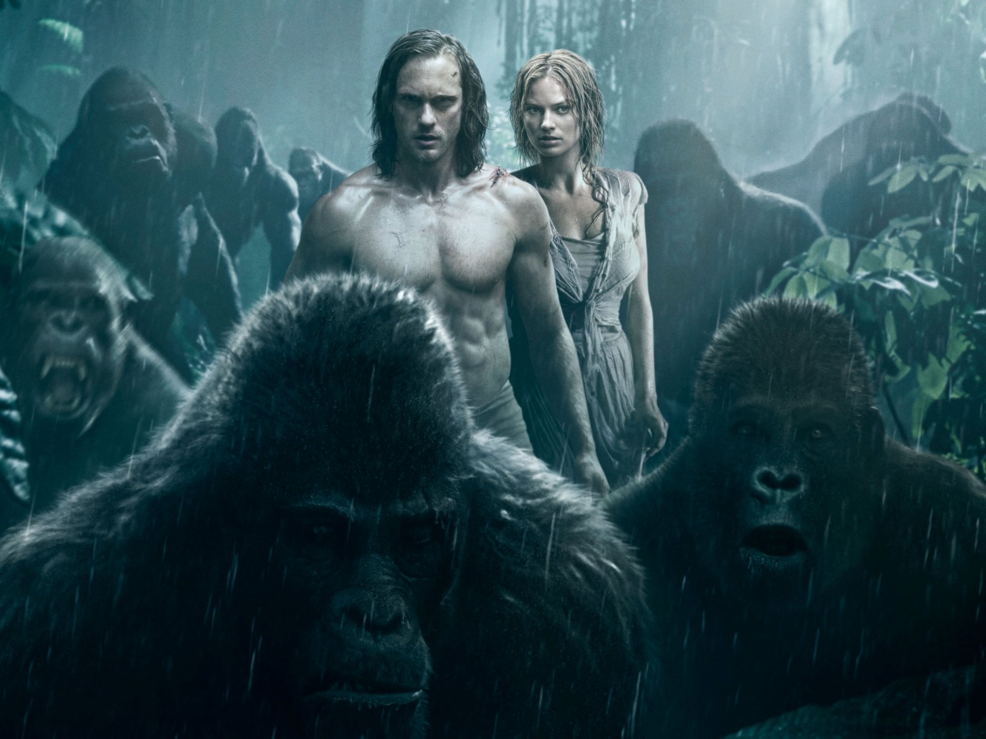 HD desktop wallpaper featuring Alexander Skarsgård as Tarzan and Margot Robbie as Jane Porter from the movie The Legend of Tarzan, surrounded by gorillas in a jungle setting.