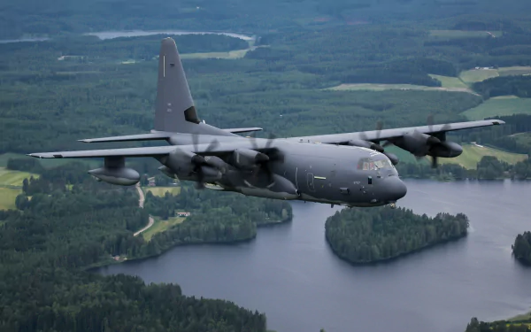 Lockheed C-130 Hercules military transport aircraft flies over a forested landscape with rivers, captured in HD for a striking warplane desktop wallpaper.