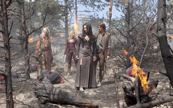 Legend of the Seeker TV scene: four figures stand in a scorched forest among burning debris; 5K Ultra HD PC desktop wallpaper background.