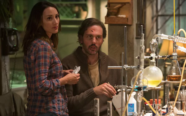 A scene from the TV show Grimm, featuring two characters in a lab environment, engaging in conversation amidst various scientific equipment. An HD PC desktop wallpaper background.