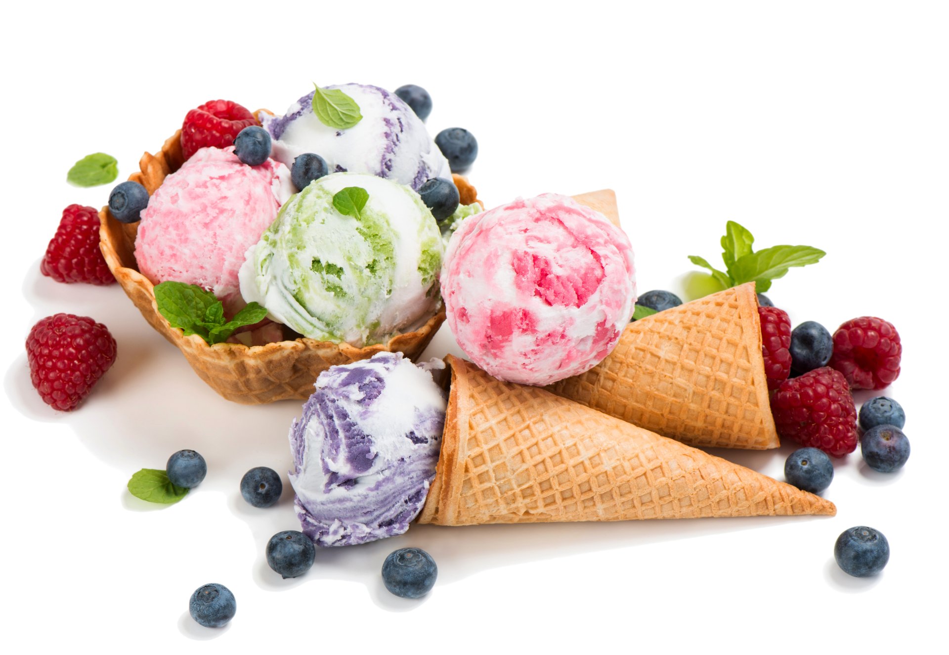 A vibrant 4K Ultra HD image of colorful ice cream scoops in waffle cones and a waffle bowl, garnished with fresh blueberries, raspberries, and mint leaves on a white background.