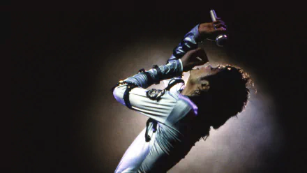 A captivating HD wallpaper of Michael Jackson passionately performing on stage, characterized by dramatic lighting and energy, celebrating his legendary music legacy.