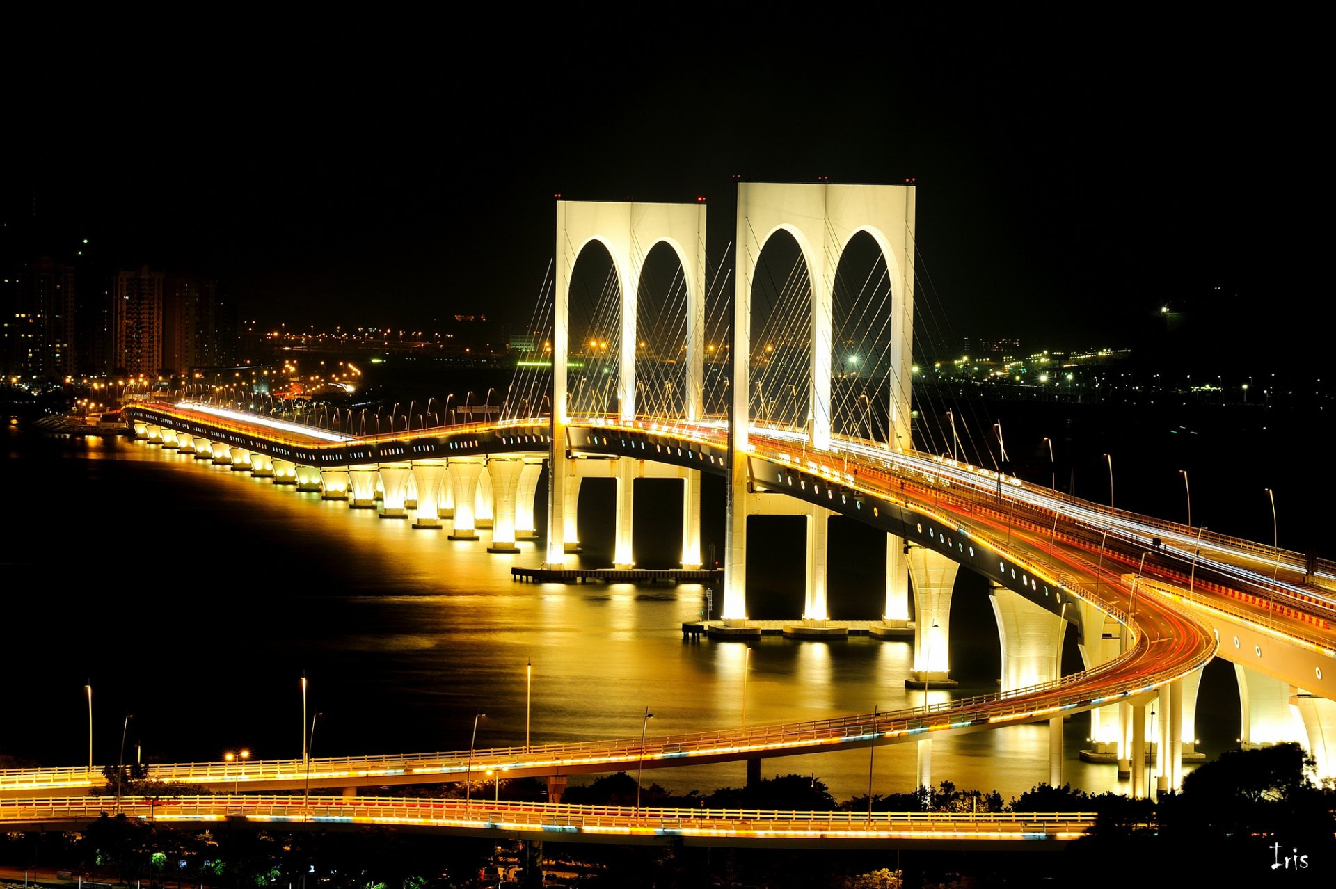 Time-lapse night view of a brightly lit modern bridge with light trails, captured in HD for a PC desktop wallpaper background.