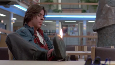 HD desktop wallpaper featuring Judd Nelson as John Bender from the movie The Breakfast Club, seated in the school library with a defiant expression.