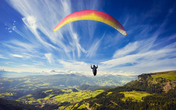 HD desktop wallpaper featuring a vibrant paragliding scene over a vast landscape with a dramatic sky and distant horizon, capturing the thrill of outdoor sports.