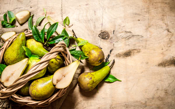 4K Ultra HD PC desktop wallpaper showing a wicker basket of pears and leaves on a rustic wooden surface — fruit/food still life background