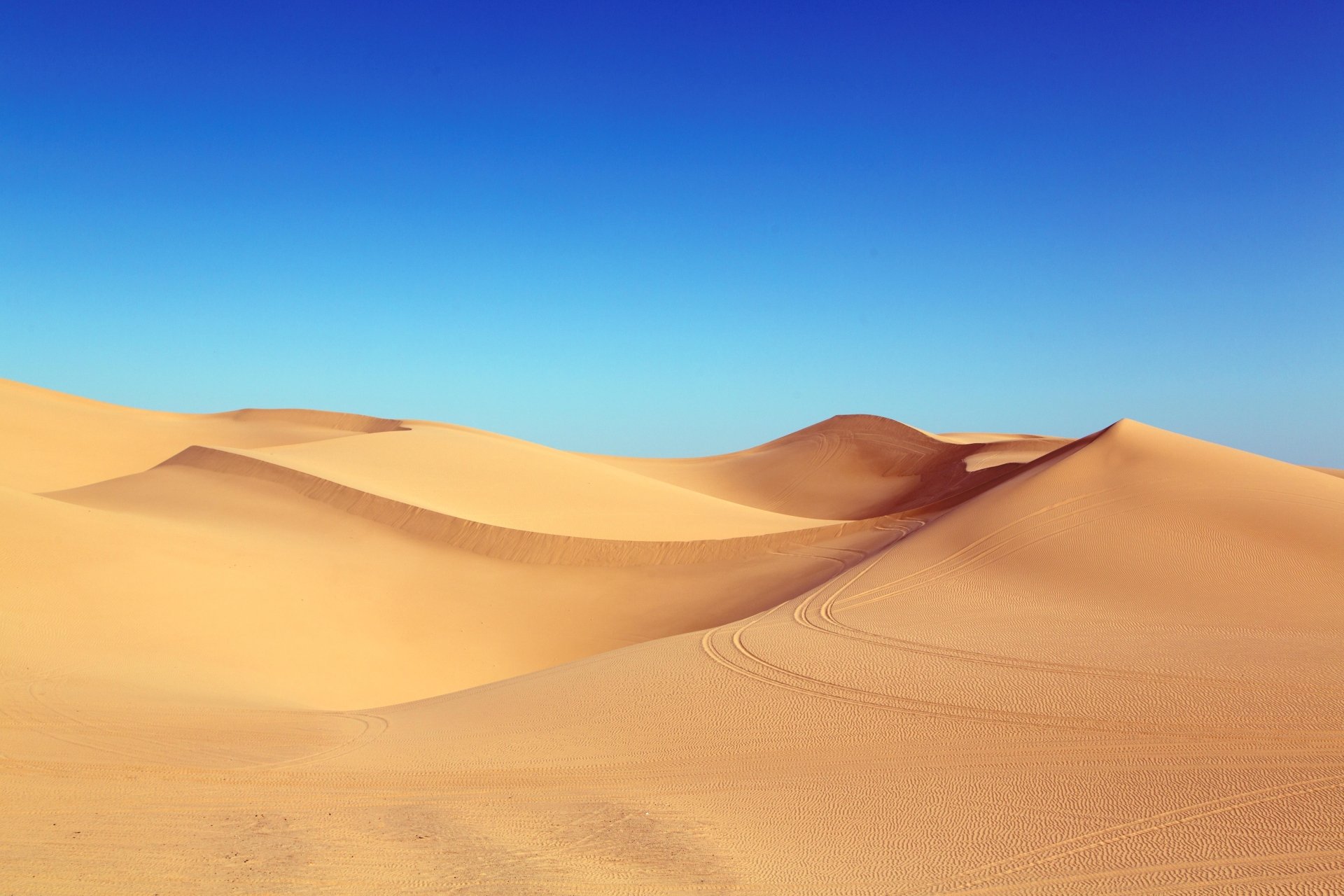 Golden desert sand dunes under a clear blue sky — 5K Ultra HD PC desktop wallpaper and background.