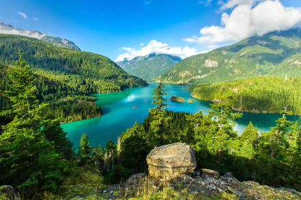 A stunning view of Diablo Lake in Washington, framed by lush forests and majestic mountains under a clear blue sky, showcasing the beauty of nature in this serene landscape.