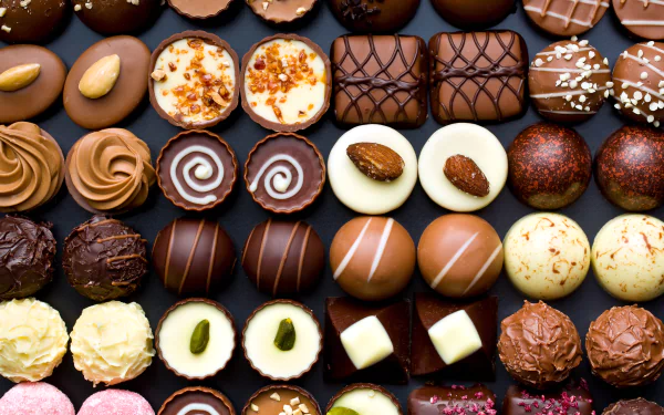 Assorted chocolates and sweets arranged in neat rows, captured in vibrant detail as a 4K Ultra HD PC desktop wallpaper and background.