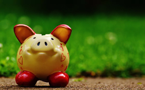 Blurred background with a man-made piggy bank featuring red hearts and red feet, captured in 4K Ultra HD for PC desktop wallpaper and background.