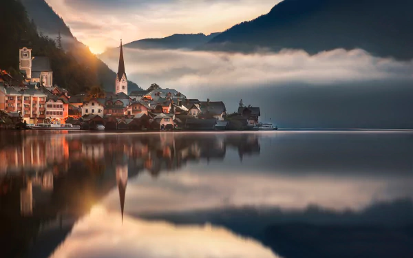 A serene view of Hallstatt, Austria, showcasing a lake reflecting the village against a backdrop of clouds and mountains, captured in stunning HD quality.
