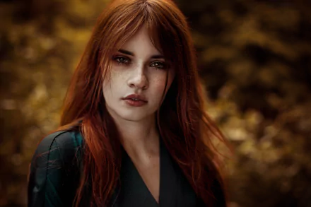 A captivating redhead woman with brown eyes and freckles gazes confidently at the camera, set against a soft, blurred background. An 8K Ultra HD image showcasing her striking features.