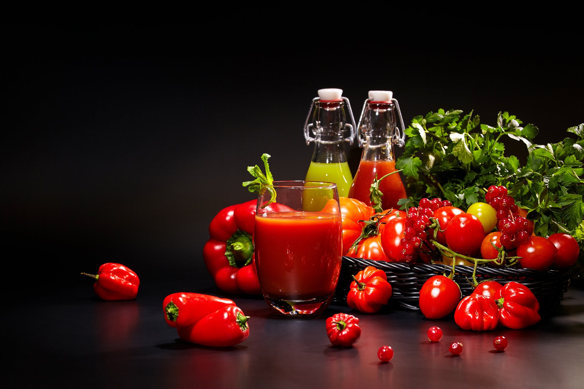 Vibrant still life of tomatoes, peppers, fresh herbs, and two bottles of juice, captured in stunning 4K Ultra HD as a desktop wallpaper and background.