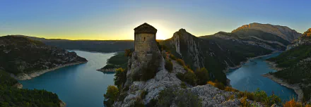 A stunning landscape of a fortress overlooking the Mare de Déu de la Pertusa lake in Spain, captured at sunrise, showcasing the natural beauty of the region.