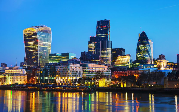 4K Ultra HD night view of London's iconic skyscrapers and buildings reflecting on the river, showcasing the vibrant cityscape of the United Kingdom.