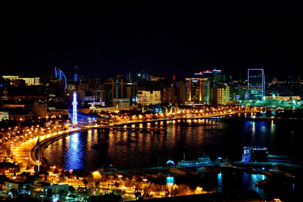 Night view of Baku's illuminated coastal cityscape in Azerbaijan, showcasing modern buildings and bright lights reflected on the water in stunning 4K Ultra HD quality.