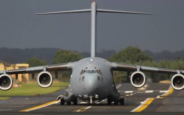 Front view of a Boeing C-17 Globemaster III military transport aircraft on a runway, captured in high-definition as a desktop wallpaper.