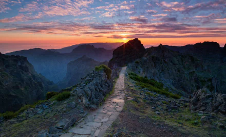 HD desktop wallpaper showcasing a man-made path winding through mountainous landscape in Portugal during a vibrant sunset.