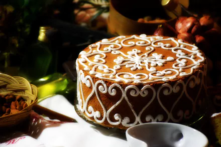 5K Ultra HD PC desktop wallpaper of a decorated pastry cake (food) with ornate white icing scrollwork, set on a table with nuts and a cup.