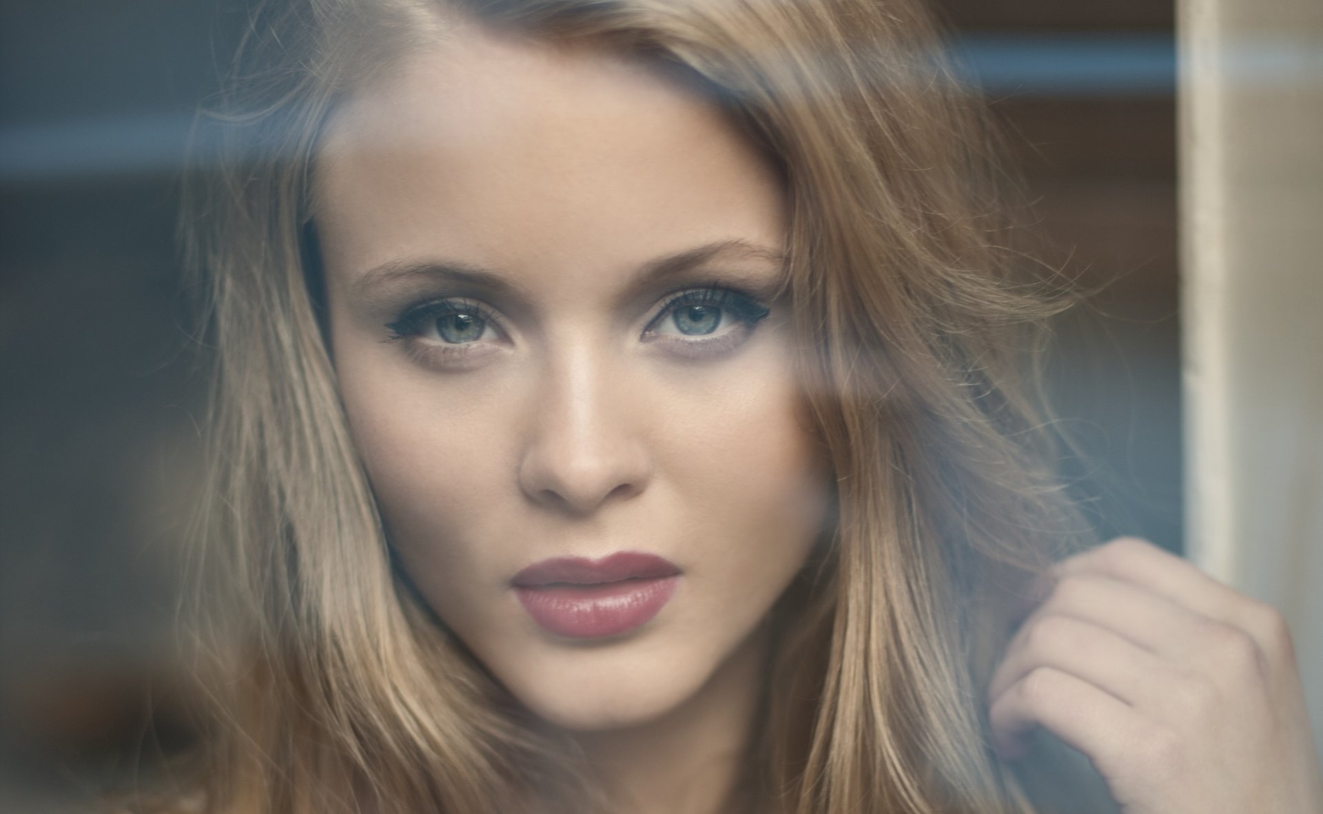 Close-up HD portrait of Swedish singer Zara Larsson with blonde hair and bold lipstick, captured in a soft-focus style for a striking desktop wallpaper background.