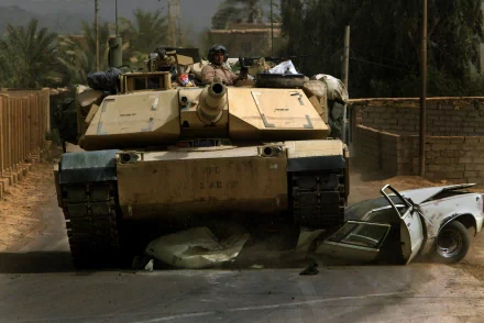A military M1 Abrams tank navigates a dusty street, showcasing its powerful presence amidst debris, serving as a striking HD desktop wallpaper and background.