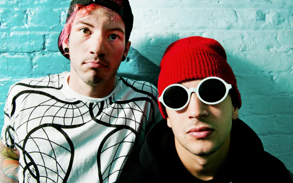 A vibrant HD wallpaper featuring the musical duo Twenty One Pilots, showcasing their distinct style against a textured blue background.