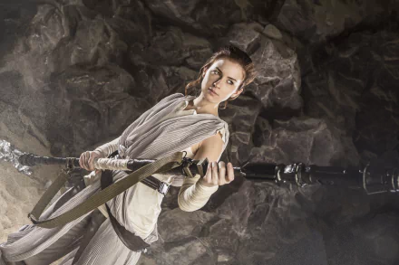 Cosplayer dressed as Rey from Star Wars holding her staff in a rocky cave — 5K Ultra HD PC desktop wallpaper.
