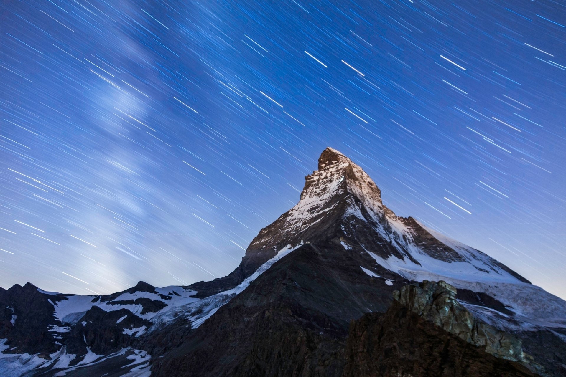 HD desktop wallpaper featuring the majestic Matterhorn peak under a starry sky with visible star trails, showcasing natural mountain beauty.