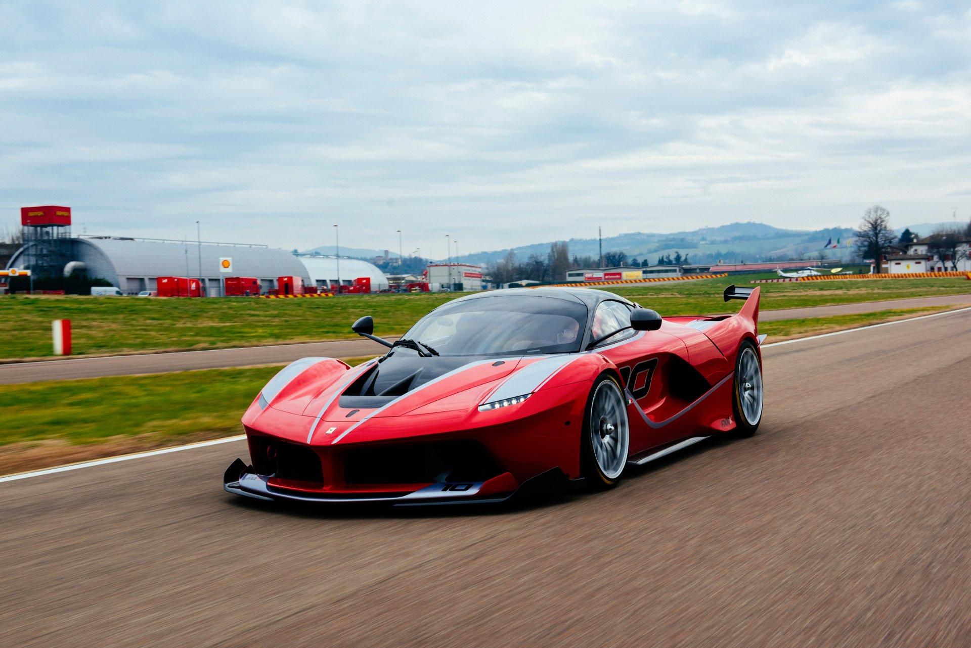 Red Ferrari FXX K racing on a track, captured in stunning 4K Ultra HD for a vivid PC desktop wallpaper background.