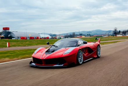Red Ferrari FXX K racing on a track, captured in stunning 4K Ultra HD for a vivid PC desktop wallpaper background.
