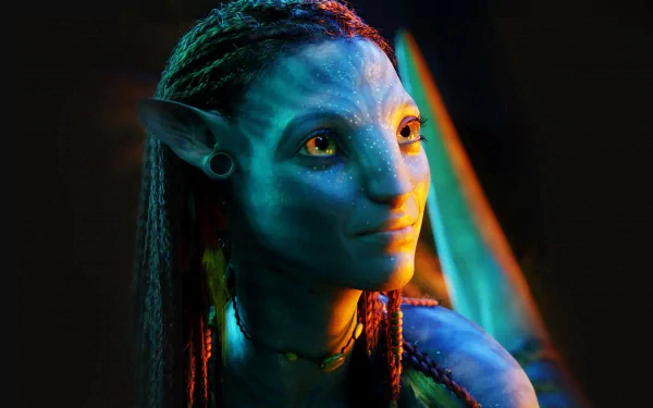 HD desktop wallpaper of Neytiri from the movie Avatar. She has yellow eyes, pointed ears, black long hair, and is wearing earrings and a necklace, while smiling softly.
