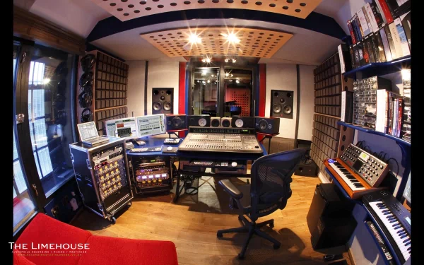 HD desktop wallpaper of a man-made recording studio room, featuring audio equipment, mixing consoles, speakers, and shelves filled with gear and books.