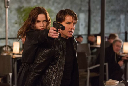 Ilsa Faust, portrayed by Rebecca Ferguson, aims a gun while standing protectively behind Ethan Hunt, played by Tom Cruise, in a tense scene from Mission: Impossible - Rogue Nation.